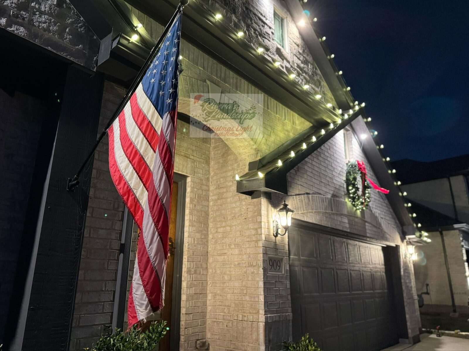 Holiday lighting installation along the roofline and entry.